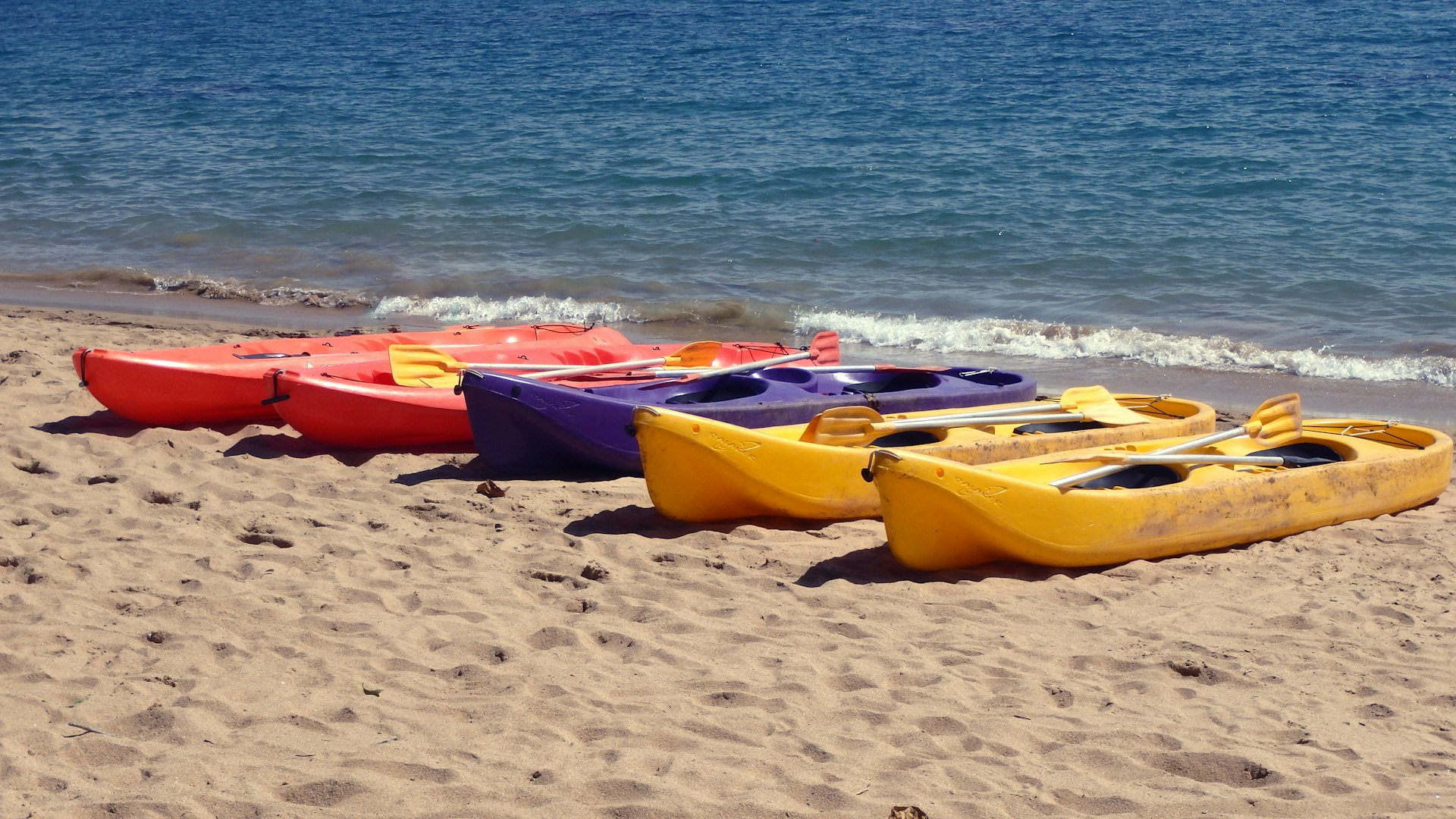 yellow and red kayaks on beach during daytime