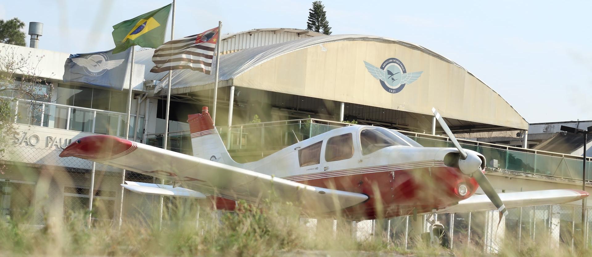 white and red airplane on green grass field during daytime